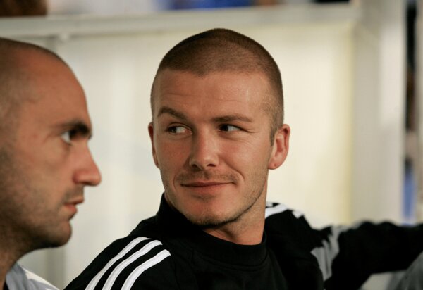 David Beckham, sporting a closely shaved head and a subtle smile