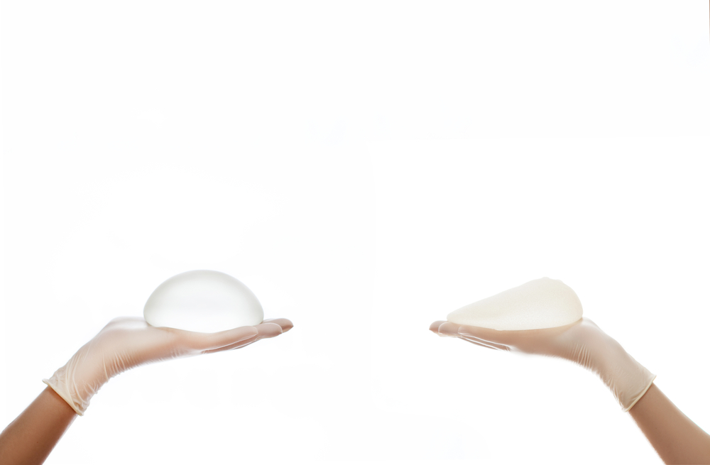 Round and teardrop breast implants on hands.